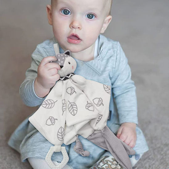 Bébé assis avec doudou renard blanc