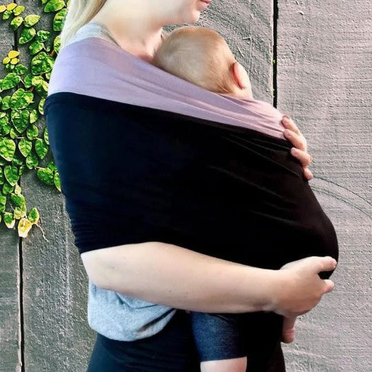 Bébé contre maman endormi dans echarpe de portage