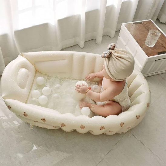 Bébé jouant avec des balles dans sa baignoire bébé gonflable
