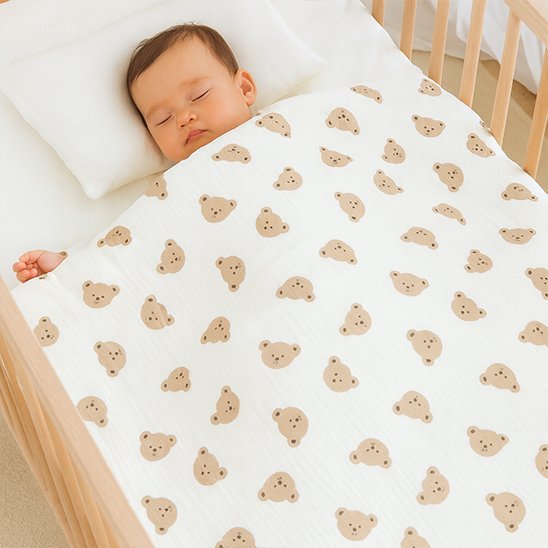 Couverture bébé en mousseline douce recouvrant bébé qui dort.