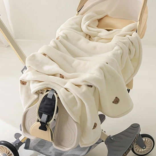 Couverture polaire déposée sur une poussette bébé.