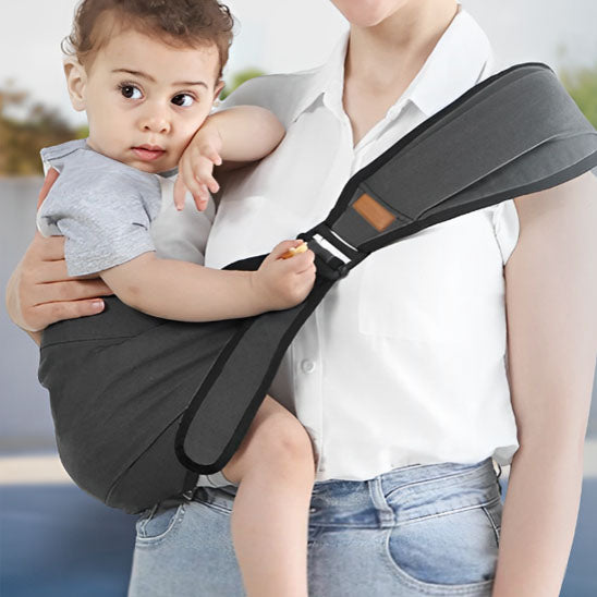 Enfant en promenade avec maman dans porte bebe gris foncé