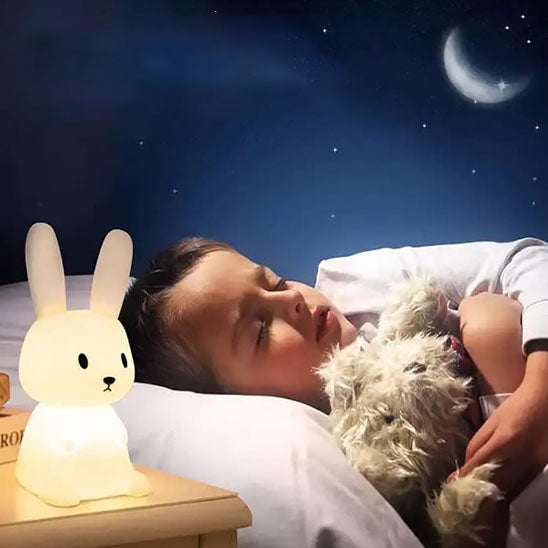 Enfant endormi avec veilleuse lapin lumineux