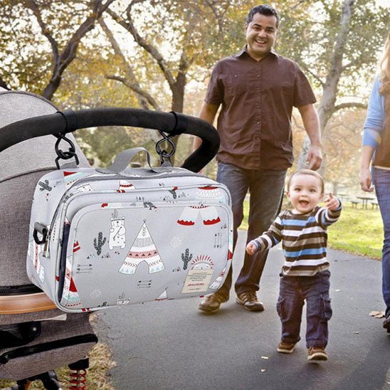 Famille en promenade au parc avec sac a langer tipis