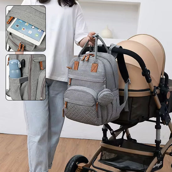 Femme accrochant sac à dos à langer gris sur poussette