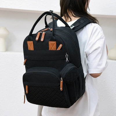 Femme portant sac à dos à langer noir