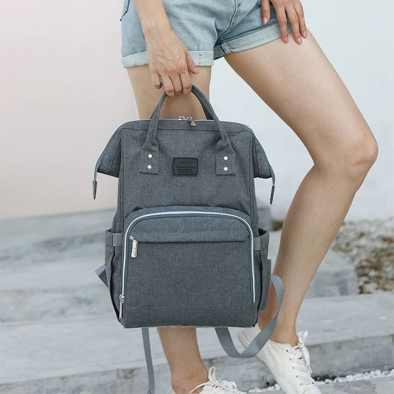 Femme tenant sac à dos à langer design mode