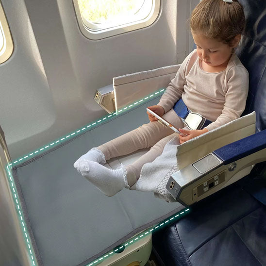 Fillette assise dans un avion sur hamac bebe confortable