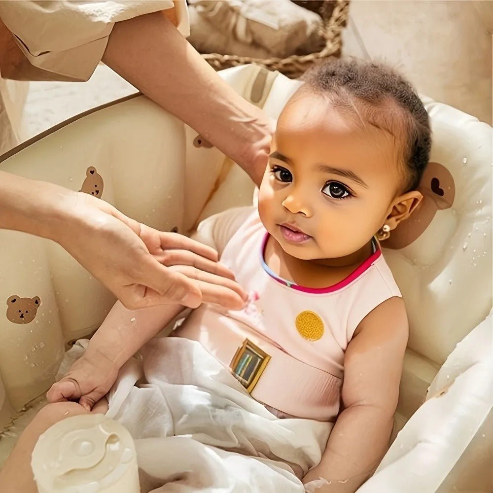 Magnifique petite fille assise dans sa baignoire bébé gonflable beige.