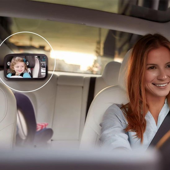 Maman dans la voiture garde un oeil sur bébé avec le miroir voiture bébé.