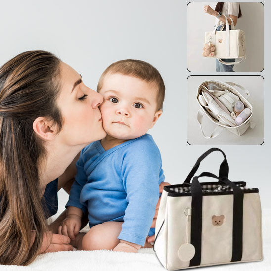 Maman embrassant bébé et sac a langer bien organisé