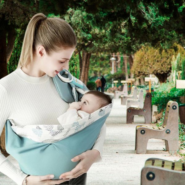 Maman en promenade au parc avec porte bébé hamac