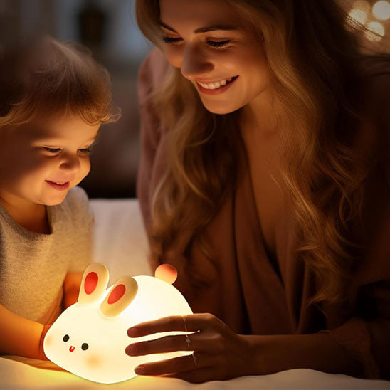 Mère et fils touchant petite veilleuse lapin
