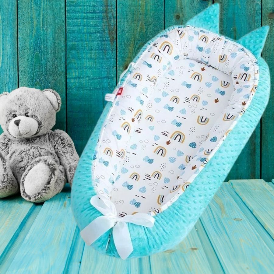 Nid d'ange sur du bois turquoise et ourson.