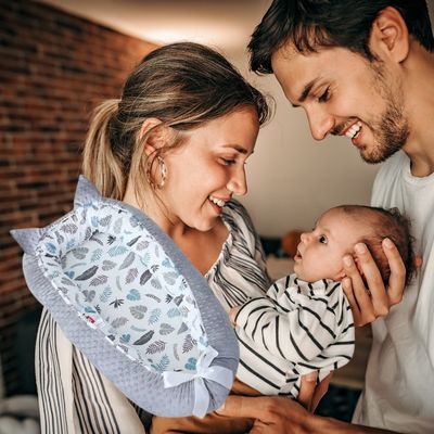 Parents regardent bébé et nid d'ange