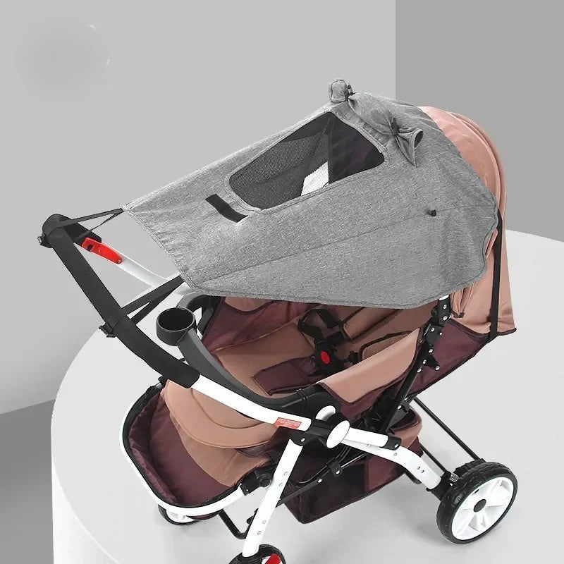 Pare-soleil gris installé sur poussette bébé