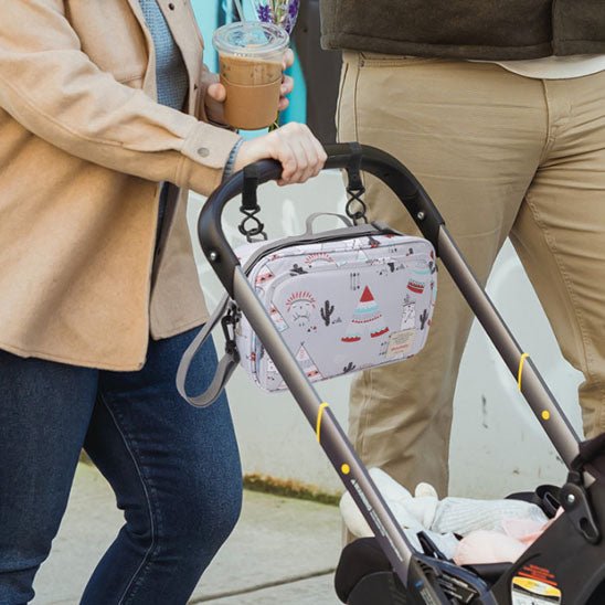 Parents en promenade et sac a langer suspendu à la poussette