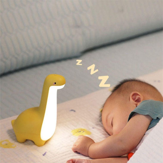Veilleuse dinosaure jaune et bébé qui dort