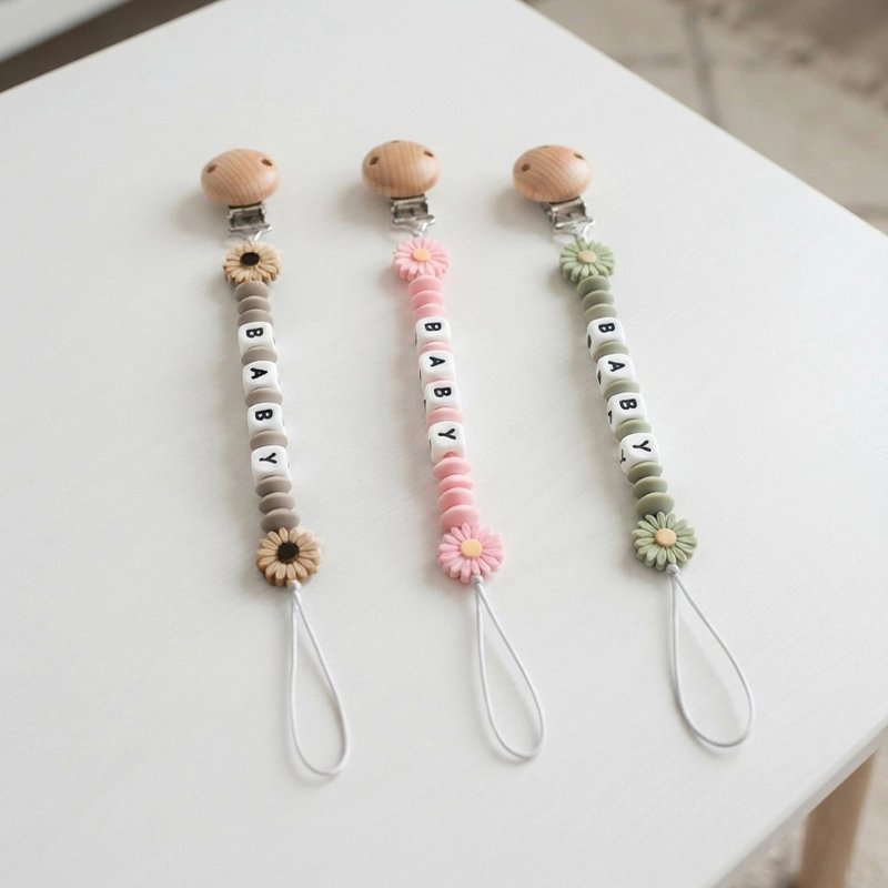 Attache tetine en silicone offerte en rose, vert ou beige.