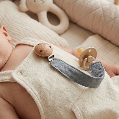 Attache tétine en tissu doux bleu clair avec clip perle en bois.