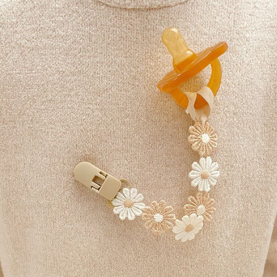 Attache tétine marguerites délicates en coton.