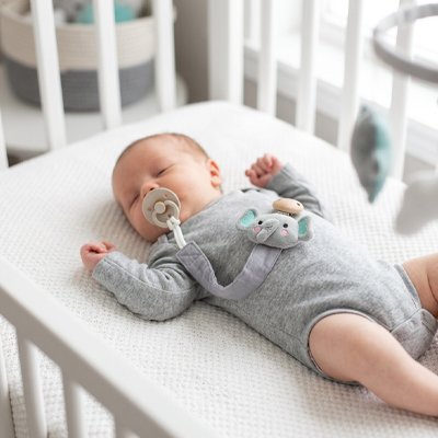 Bébé endormi avec son attache tetine éléphant gris.