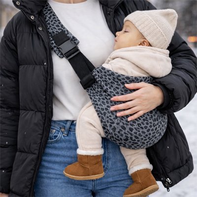 Bébé endormi dans son écharpe de portage bébé d'hiver.