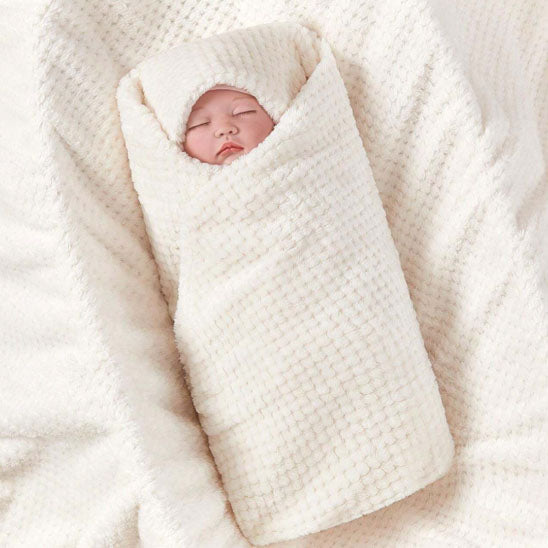 Bébé endormi emmailloté dans sa couverture bebe polaire vanille.