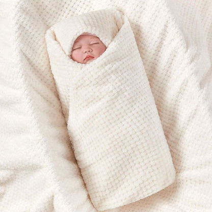Bébé endormi emmailloté dans couverture polaire vanille