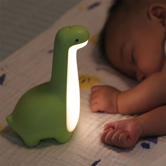 Bébé endormi et veilleuse dinosaure verte