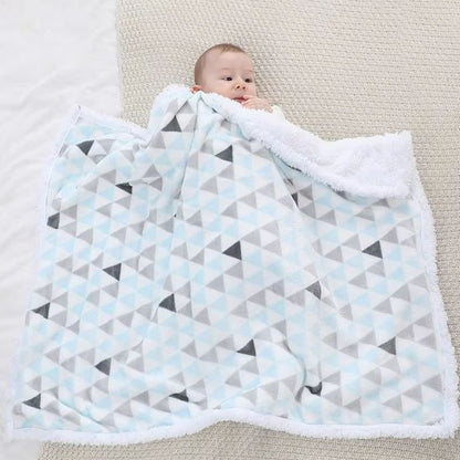 Bébé étendu au sol avec sa couverture polaire moelleuse et moderne.