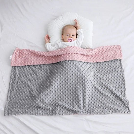 Bébé fait la sieste avec sa douce couverture bebe.