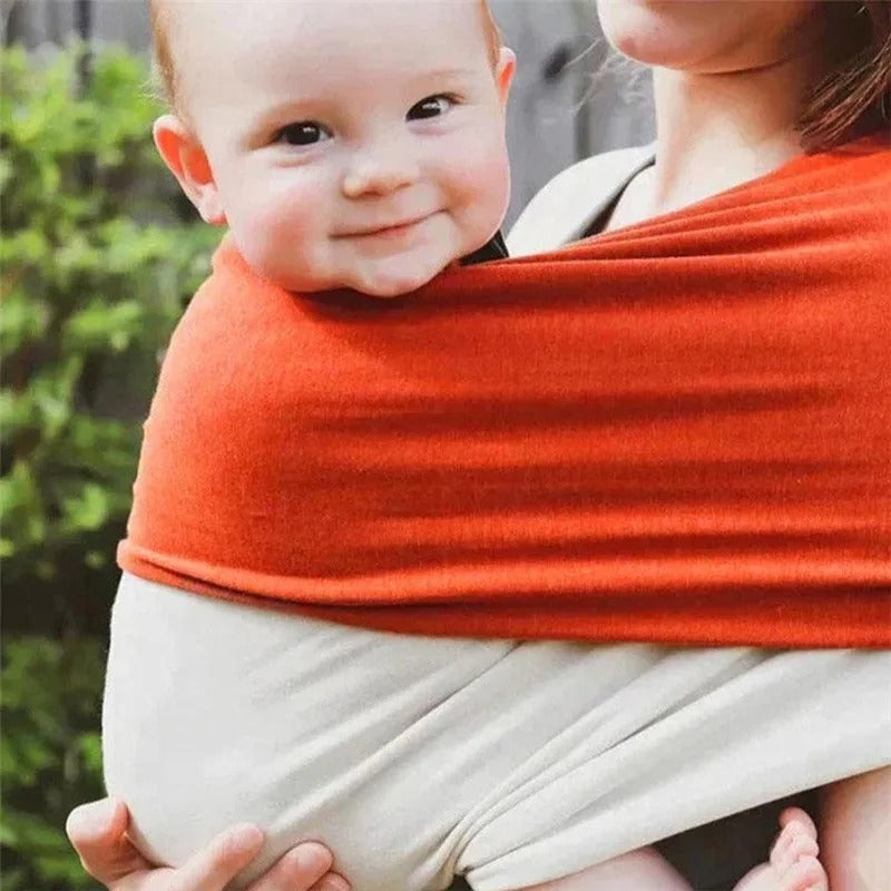Bébé heureux confortable dans echarpe de portage