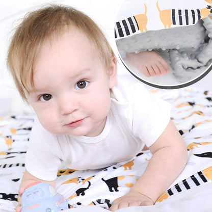 Bébé joue sur le ventre sur sa couverture bébé moelleuse.