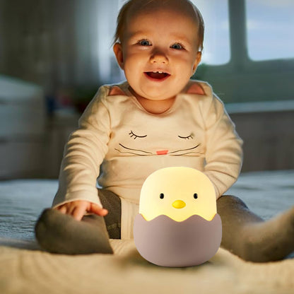 Bébé joyeux assis avec veilleuse bébé poussin