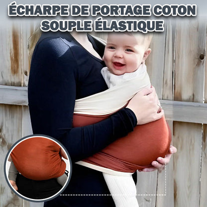 Bébé joyeux installé dans echarpe de portage coton