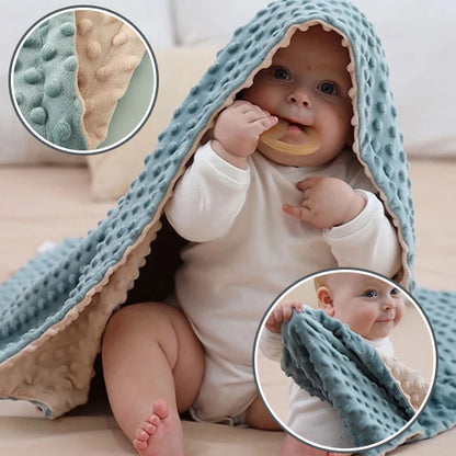 Bébé mordant un anneau de dentition sous couverture bebe