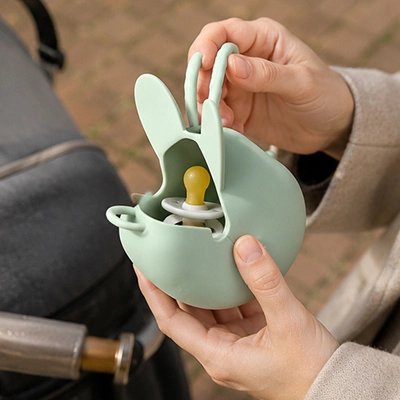 Boite a tetine​ vert tendre en silicone souple à ouverture facile.