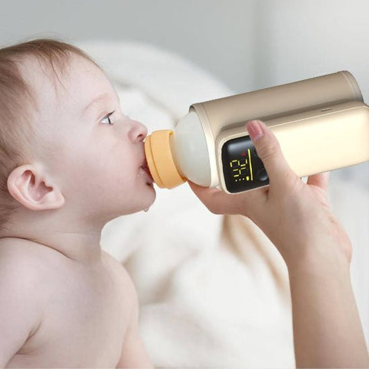 Bébé buvant son lait avec chauffe biberon nomade