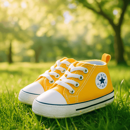 Chaussures bebe mode jaunes déposées sur la pelouse