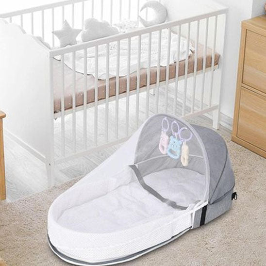 Couffin bebe avec moustiquaire déposé sur sol chambre bébé