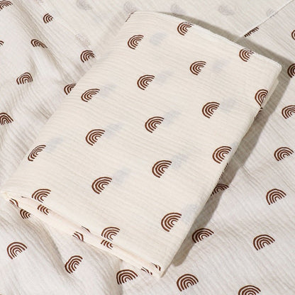 Couverture bébé en mousseline de coton avec arcs-en-ciel.