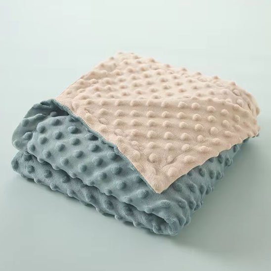 Couverture bebe en polaire texturée bleue et beige.