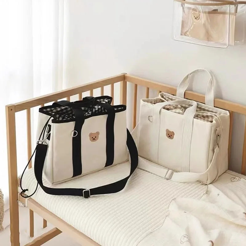 Duo de sac a langer déposés sur un lit de bébé.