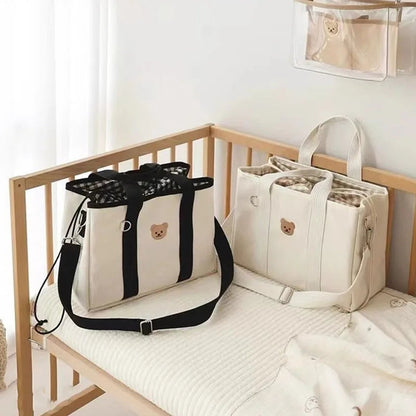 Duo de sac a langer déposés sur un lit de bébé.