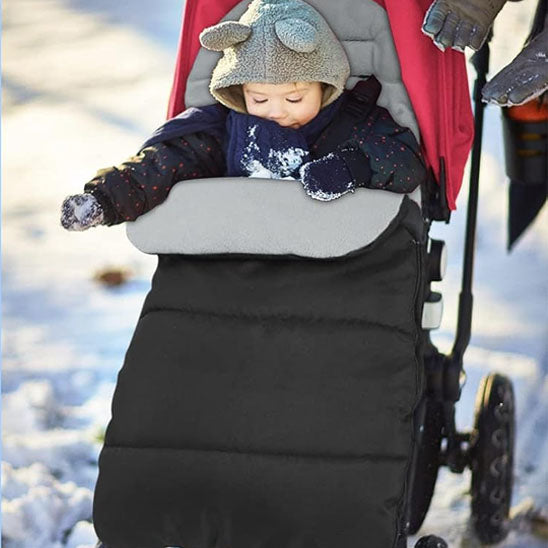 Enfant dans chancelière pour poussette hiver