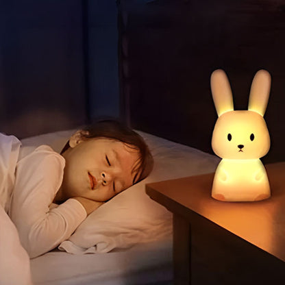 Enfant dormant avec veilleuse lapin sur table de chevet