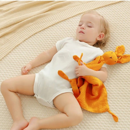 Enfant endormi serrant doudou lapin mousseline