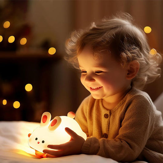 Enfant heureux tenant veilleuse lapin entre ses mains