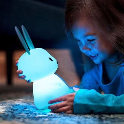 Enfant qui s'amuse avec veilleuse lapin- 